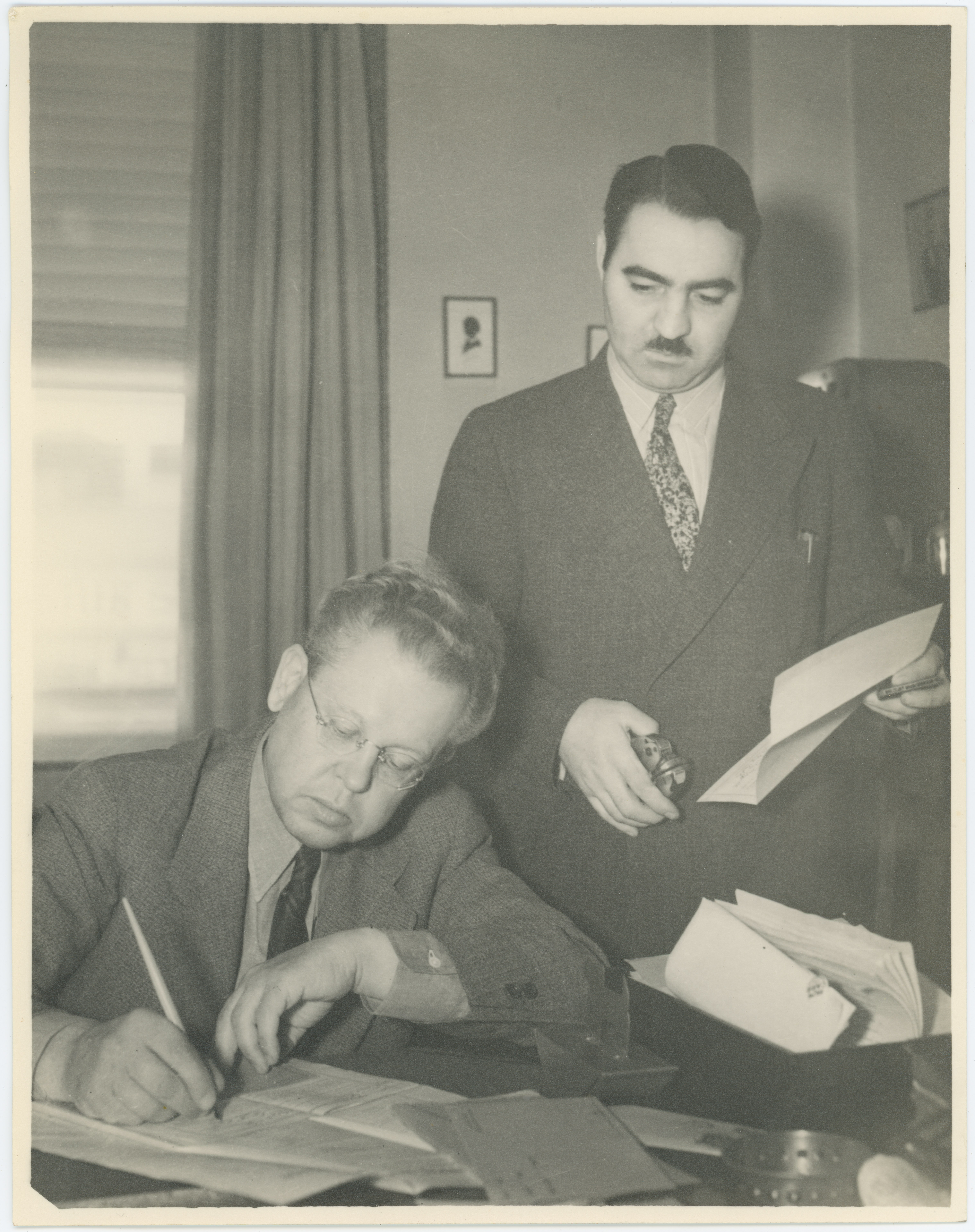 Governor Ralph Carr signing a ballot as Mazzulla watches