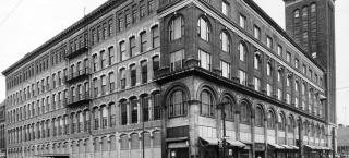 A street-level view of the corner of the historic Daniels and Fisher store and tower.