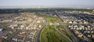 Photo of the Central Park (formerly Stapleton) area of Denver, aerial view. In the distance the skyscrapers of downtown Denver can be seen, as well as the mountains of the Front Range.
