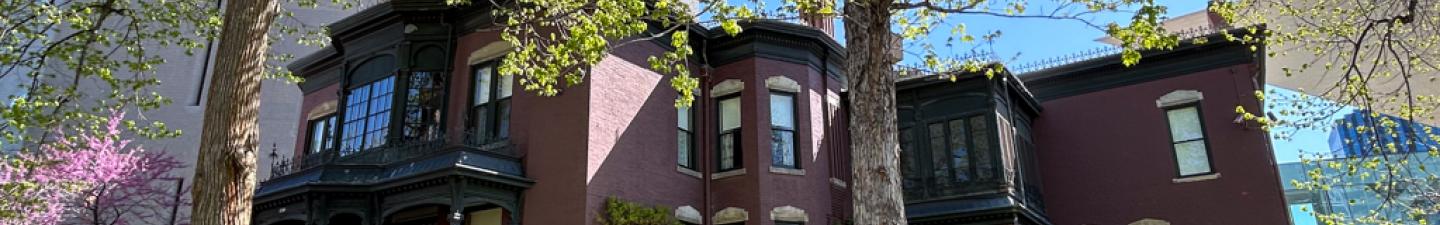 Exterior of the Center for Colorado Women's History surrounded by its lush, green lawn and several trees.