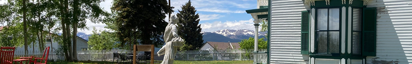Gardens at Healy House. There's a view of mount massive in the background and a stone statue in front.