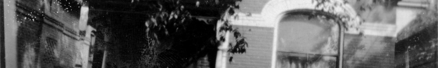 A photo of a small clapboard house, with the handwritten caption "Our Little Love Nest."