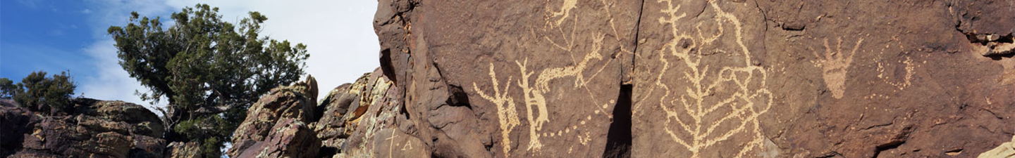 Shavano valley cliffs with light brown petroglyphs of people and animals on them.