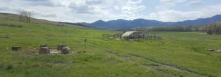 A few low concrete and stone structures, fenced off, stand in the middle of rolling green hills. These are the remnants of the Industrial Mine.