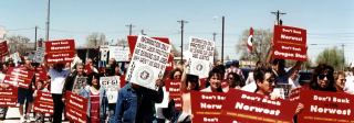 A marching protest of Pueblo steelworkers and supporters. They carry signs reading "Don't Bank with Northwest. Don't Bank on Oregon Steel."