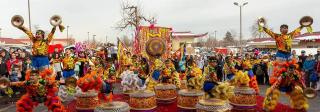 Performers dressed in brightly colored costume surrounded by matching props, banners, and flags.