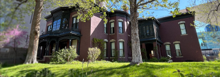 Exterior of the Center for Colorado Women's History surrounded by its lush, green lawn and several trees.
