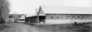 Exterior of Fort Lewis Boarding School with a view of a one story building with small windows and a porch.