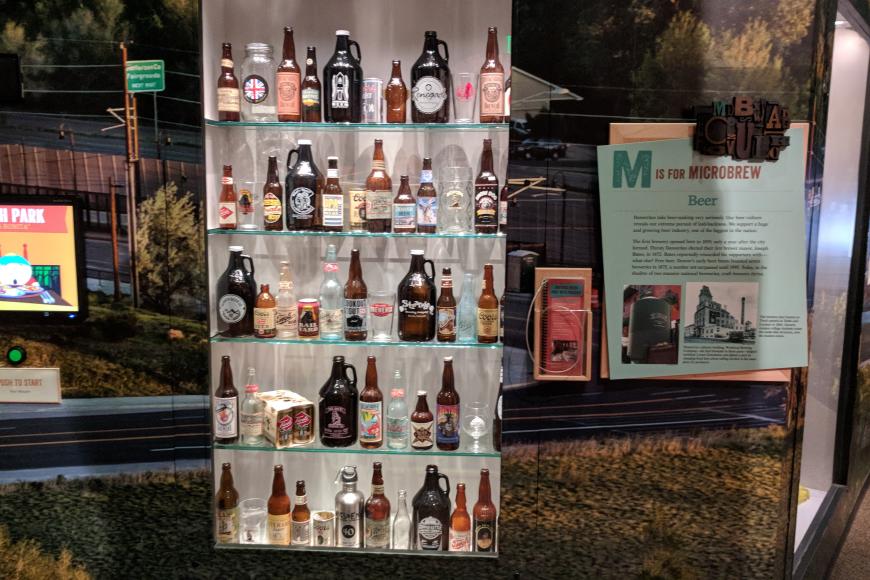 Microbrew beer bottles in a display case.