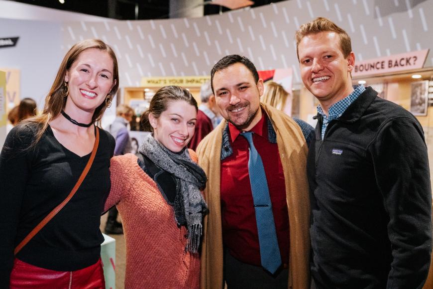 A group of museum members posing and enjoying themselves in the "What's Your Story" exhibit at the History Colorado Center.