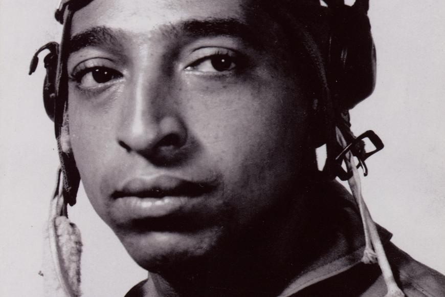 A man's portrait wearing aviation goggles on his head.