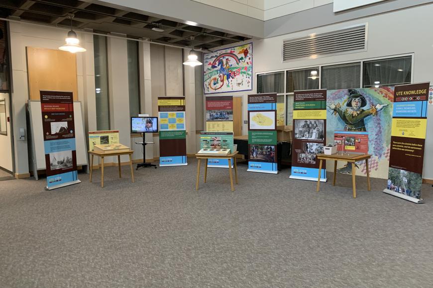 A collection of stand-up panels on display in a large open room. The panels contain information about the Ute way of life and STEM.