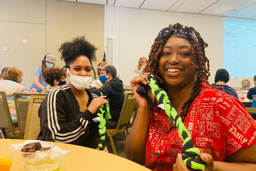 Volunteer Family Day participants making cloth dog toys for dogs in animal shelters