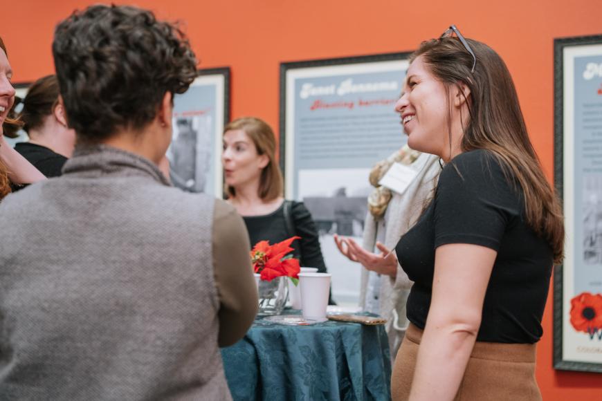 People stand around a table talking
