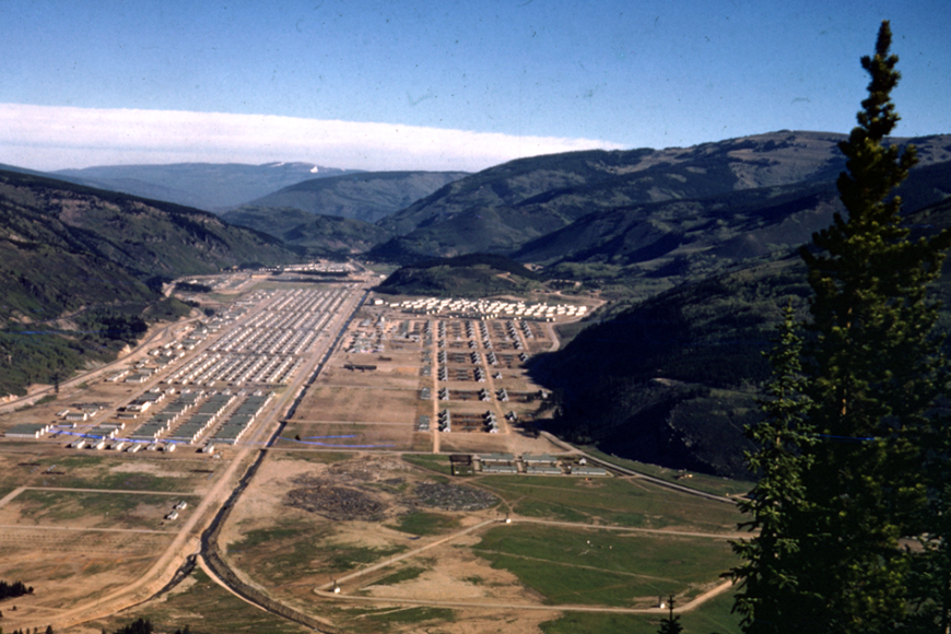 Aerial view of Camp Hale and its many barracks in summer on a green landscape.