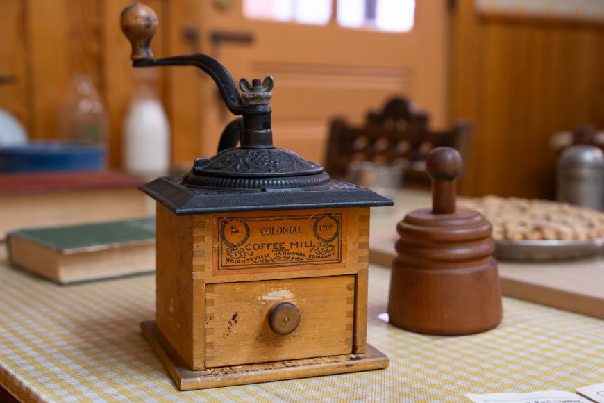 Historic coffee grinder with large metal crank.
