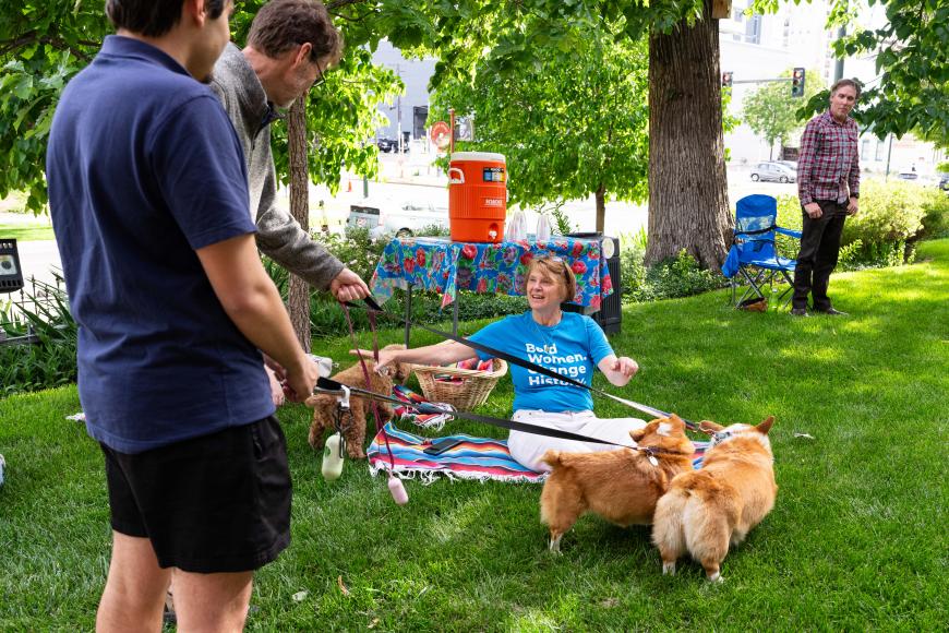 Lawn of the center for Colorado Women's History where some guests on a picnic blanket greet some leashed dogs.