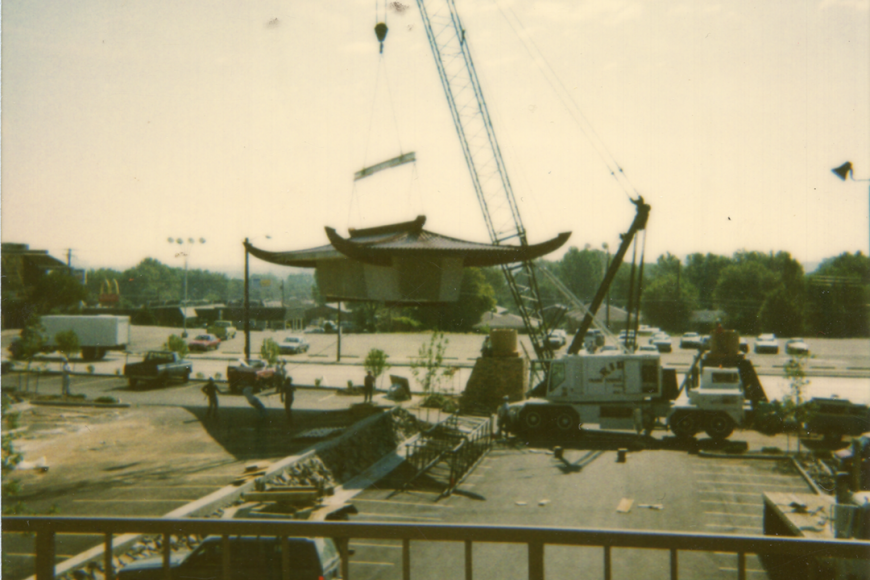 Construction of the Far East Center. A crane lowers the iconic asian style arch into position.