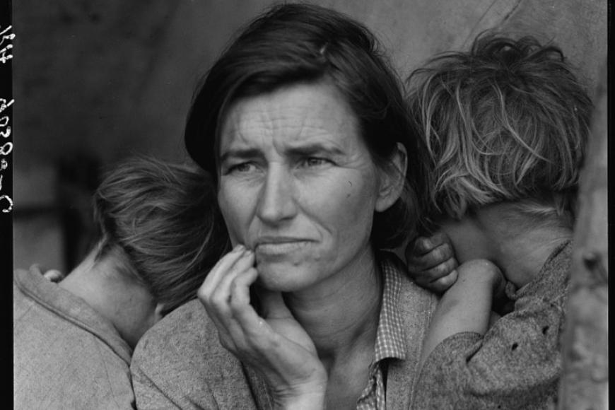 Portrait of Dorothea Lange with her two children leaning on her shoulders facing away from the camera.