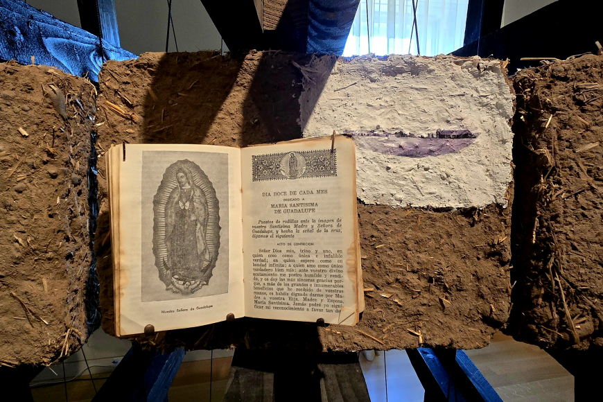 Artwork by Ronald Rael made with dirt, handmade paper, and religious texts.