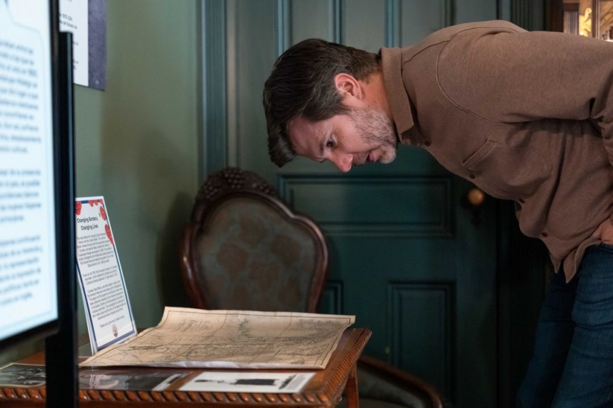 Man engaging with exhibit reading text