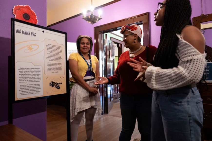 Group of women look at exhibit.