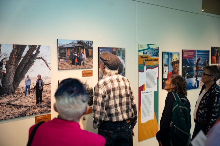 Visitors standing and viewing historical photographs and panels in the Keeping Place Colorado Heritage exhibit