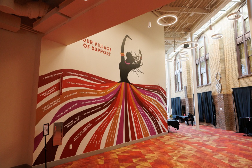 Mural of silhouetted woman dancing, her dress flows out into red toned stripes. at Cleo Parker Robinson Dance