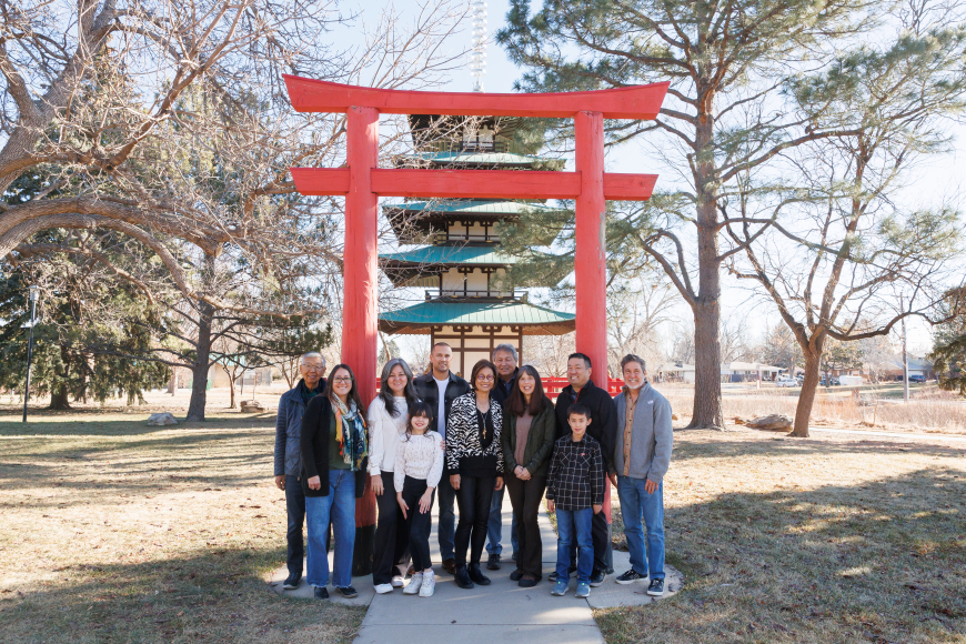 Group of people post in front of the red Tower of Compassion at Kanemoto Park