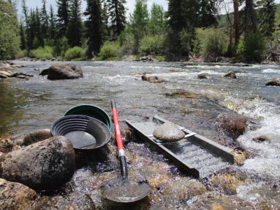 Gold panning supplies: gold pan, classifier, shovel, and sluice.