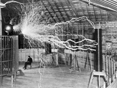 A multiple exposure picture of Tesla sitting next to his "magnifying transmitter" generating millions of volts. The 7-metre (23 ft) long arcs were not part of the normal operation, but only produced for effect by rapidly cycling the power switch.