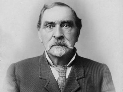 Black and white photograph of Barney Ford looking into the camera, wearing a suit jacket and a tie.