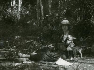 Laura Evans holding her dog, Mister Pimp Powers, while standing near a river. 