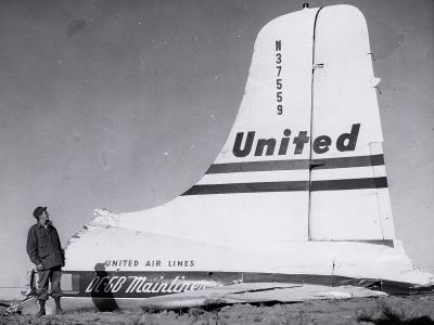 A man next to the destroyed tail section of Flight 629 in the field