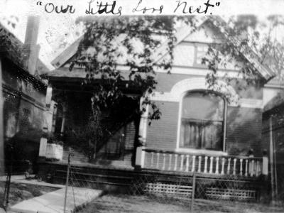 A photo of a small clapboard house, with the handwritten caption "Our Little Love Nest."