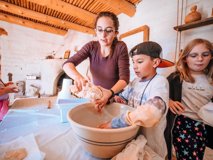 Hands-On History students and teacher making tortillas in a large bowl