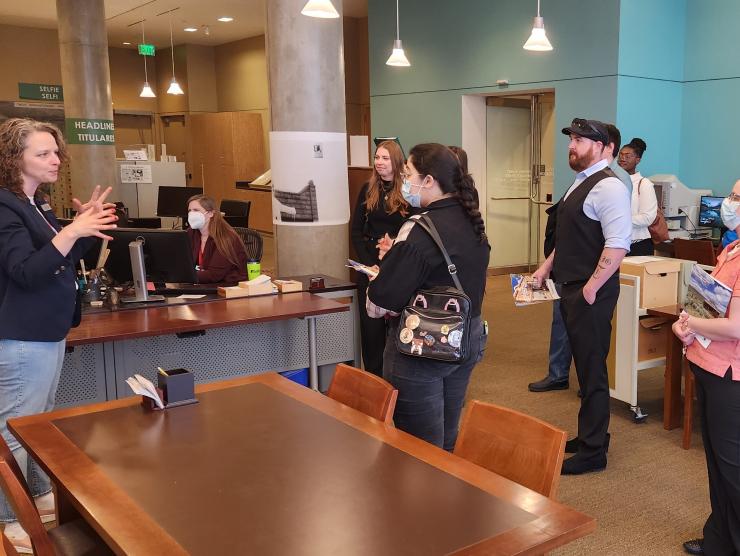 Exhibits and Loan Registrar Kimberly Kronwall speaking to a group of visitors in the Stephen H. Hart research center by a large table.