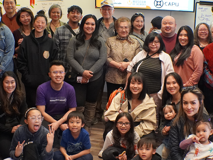 A large, diverse group of participants smiling at the camera with adults and children. Part of the Little Saigon memory project.