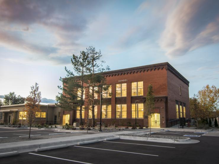 Exterior of Fruitdale Lofts at dusk, each of its large square windows are lit from within.