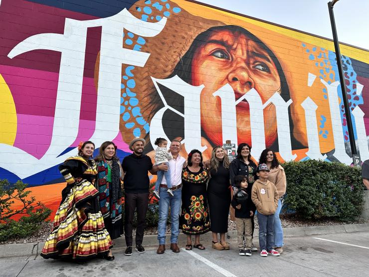The Cabellero Family,Yadira Solis, and Betty Aragon Mitotes pose in front of the Para Mi Familia mural.