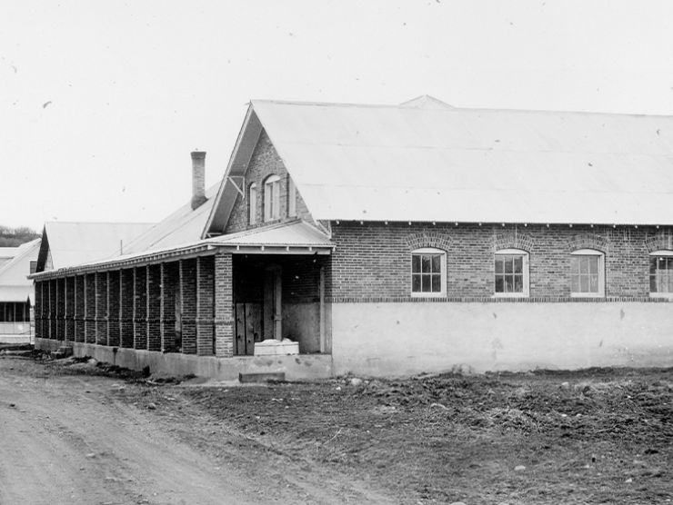 Exterior of Fort Lewis Boarding School with a view of a one story building with small windows and a porch.