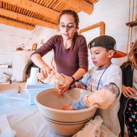 Hands-On History students and teacher making tortillas in a large bowl