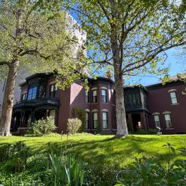 Exterior of the Center for Colorado Women's History surrounded by its lush, green lawn and several trees.